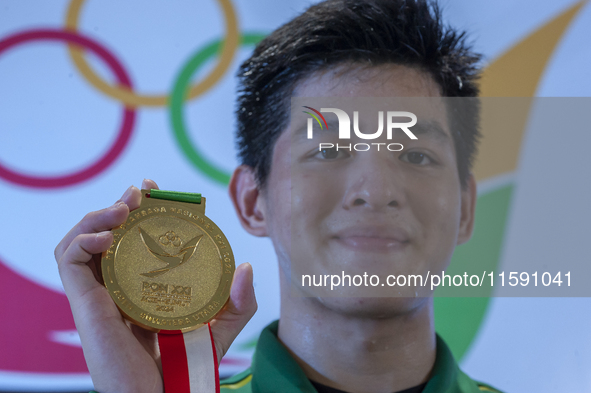 East Java Jiu Jitsu athlete, Artz Brilliant, bites the gold medal he wins after competing in the Fighting System men's -77 kg class against...