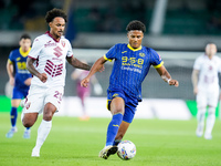 Amin Sarr of Hellas Verona and Valentino Lazaro of Torino FC compete for the ball during the Serie A Enilive match between Hellas Verona and...