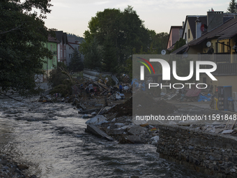 Morawka river flows by debris and damaged houses left by the flood in Stronie Slaskie, Poland on September 20, 2024. (