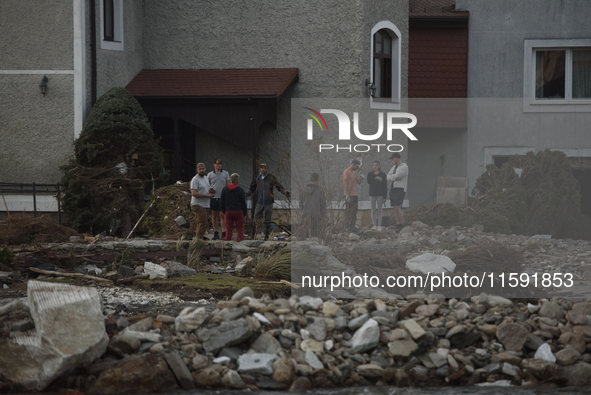 People talk outside their damaged house after a flood hit the town of Stronie Slaskie, Poland on September 20, 2024. 