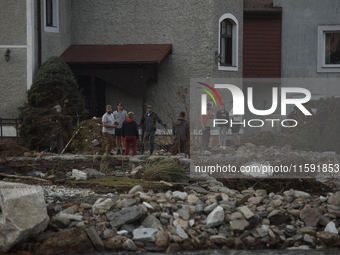 People talk outside their damaged house after a flood hit the town of Stronie Slaskie, Poland on September 20, 2024. (