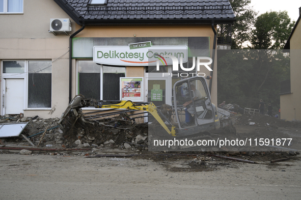 A man removes debris left by the flood wave in Stronie Slaskie, Poland on September 20, 2024. 