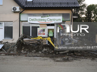 A man removes debris left by the flood wave in Stronie Slaskie, Poland on September 20, 2024. (