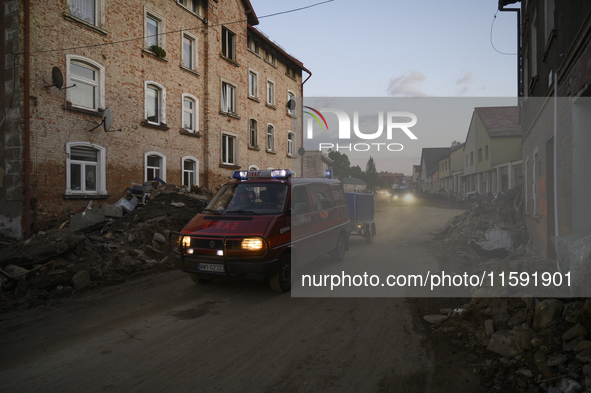 Firefighters pass by debris and damaged houses left by the flood in Stronie Slaskie, Poland on September 20, 2024. 