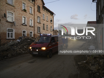 Firefighters pass by debris and damaged houses left by the flood in Stronie Slaskie, Poland on September 20, 2024. (