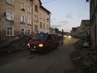 Firefighters pass by debris and damaged houses left by the flood in Stronie Slaskie, Poland on September 20, 2024. (