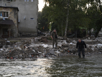 A man enters into the Morawka river to clean his boots after the flood left debris and damaged houses in Stronie Slaskie, Poland on Septembe...