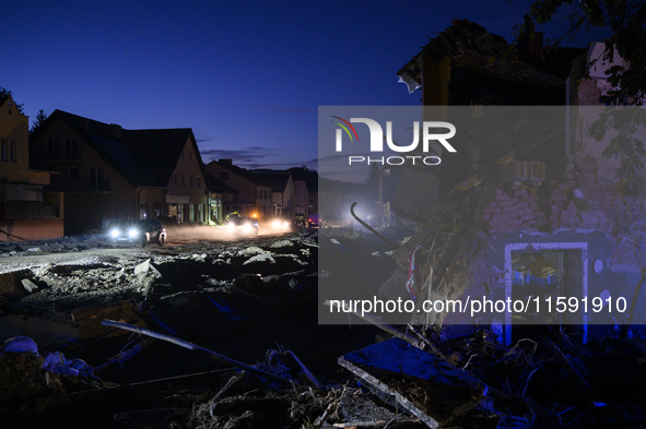 Cars pass by damaged buildings at sunset after a flood hit the town of  Stronie Slaskie, Poland on September 20, 2024. 