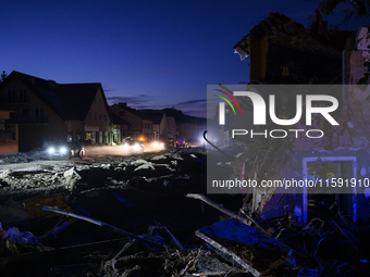 Cars pass by damaged buildings at sunset after a flood hit the town of  Stronie Slaskie, Poland on September 20, 2024. (