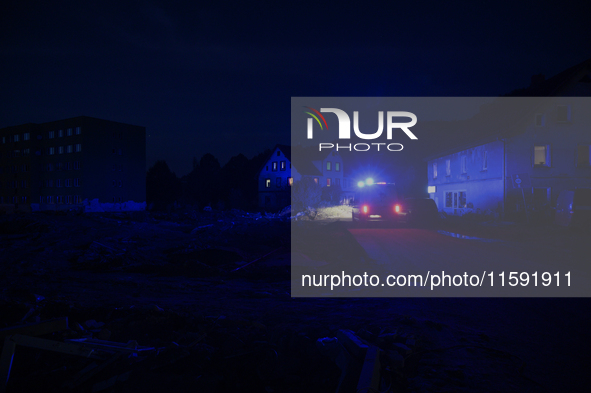 Police pass by damaged buildings and debris after a flood hit the town of  Stronie Slaskie, Poland on September 20, 2024. 