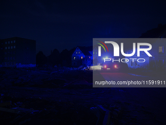 Police pass by damaged buildings and debris after a flood hit the town of  Stronie Slaskie, Poland on September 20, 2024. (