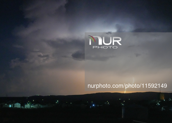 A lightning bolt illuminates the sky over northwest Syria, above the refugee camps, on September 20, 2024. The horizon flashes with the ligh...