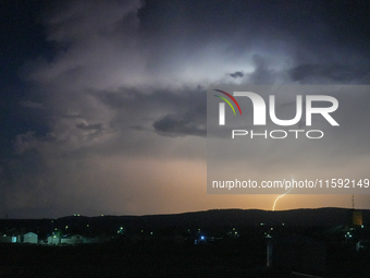 A lightning bolt illuminates the sky over northwest Syria, above the refugee camps, on September 20, 2024. The horizon flashes with the ligh...