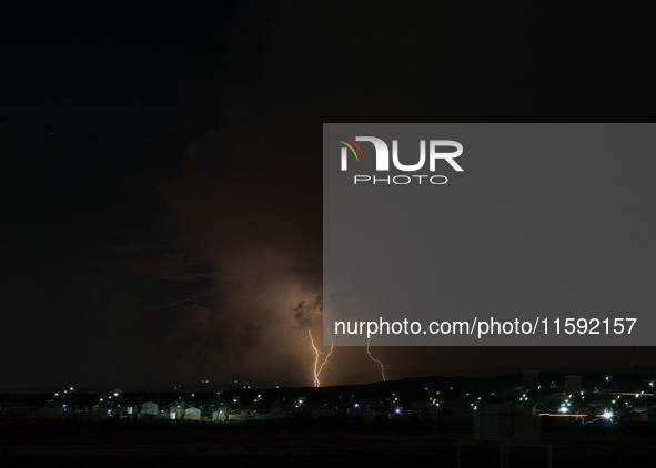 A lightning bolt illuminates the sky over northwest Syria, above the refugee camps, on September 20, 2024. The horizon flashes with the ligh...