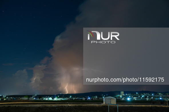 A lightning bolt illuminates the sky over northwest Syria, above the refugee camps, on September 20, 2024. The horizon flashes with the ligh...