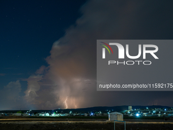 A lightning bolt illuminates the sky over northwest Syria, above the refugee camps, on September 20, 2024. The horizon flashes with the ligh...