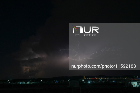 A lightning bolt illuminates the sky over northwest Syria, above the refugee camps, on September 20, 2024. The horizon flashes with the ligh...