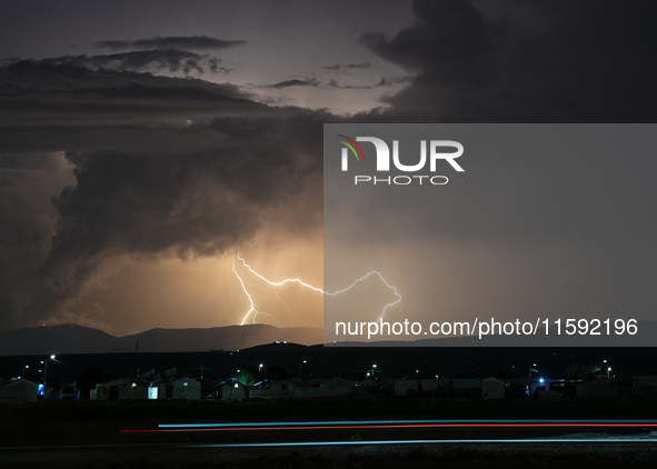 A lightning bolt illuminates the sky over northwest Syria, above the refugee camps, on September 20, 2024. The horizon flashes with the ligh...