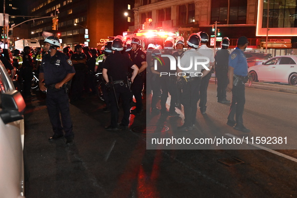 Police watch as protesters march. Protesters demonstrate and make their voices heard for Black and Palestinian liberation following the subw...