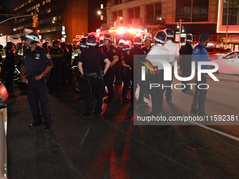 Police watch as protesters march. Protesters demonstrate and make their voices heard for Black and Palestinian liberation following the subw...