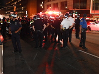 Police watch as protesters march. Protesters demonstrate and make their voices heard for Black and Palestinian liberation following the subw...