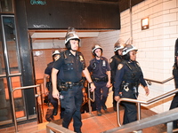 Police guard the subway. Protesters demonstrate and make their voices heard for black and Palestinian liberation following the subway shooti...