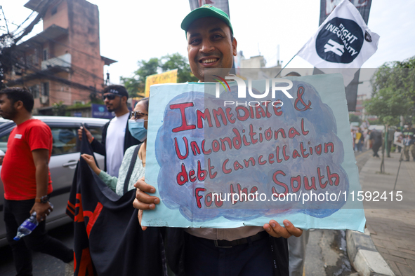 A Nepali activist displays a slogan calling for climate justice during a march to mark the Global Week of Action for Peace and Climate Justi...