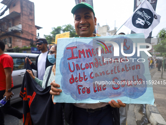 A Nepali activist displays a slogan calling for climate justice during a march to mark the Global Week of Action for Peace and Climate Justi...