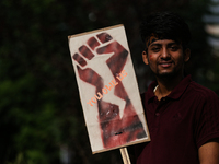 A Nepali activist poses for a photo displaying a placard calling for climate justice during a march to mark Global Week of Action for Peace...