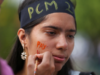 A Nepali activist paints her face with slogans calling for climate justice during a march to mark Global Week of Action for Peace and Climat...