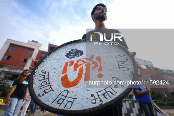 A Nepali activist displays a slogan calling for climate justice during a march to mark the Global Week of Action for Peace and Climate Justi...