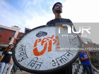 A Nepali activist displays a slogan calling for climate justice during a march to mark the Global Week of Action for Peace and Climate Justi...