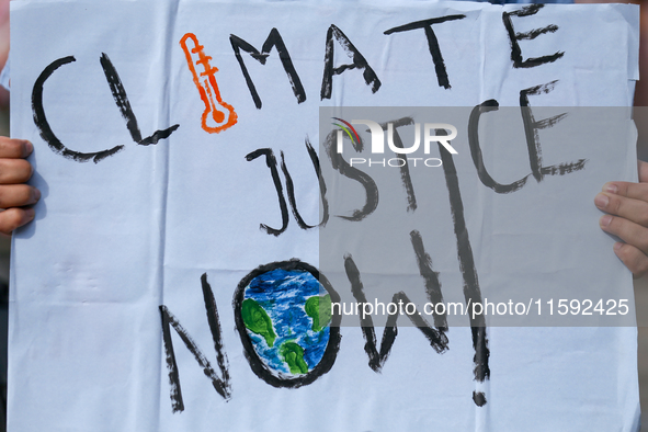 A Nepali activist displays a slogan calling for climate justice during a march to mark the Global Week of Action for Peace and Climate Justi...