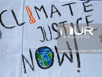 A Nepali activist displays a slogan calling for climate justice during a march to mark the Global Week of Action for Peace and Climate Justi...