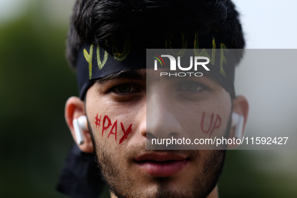 A Nepali activist poses for a photo with slogans calling for climate justice on his face during a march to mark Global Week of Action for Pe...