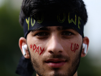 A Nepali activist poses for a photo with slogans calling for climate justice on his face during a march to mark Global Week of Action for Pe...