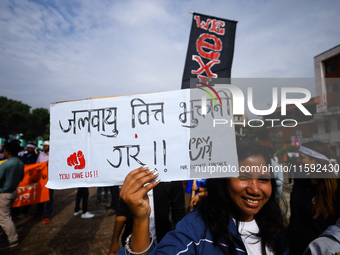 A Nepali activist displays a slogan calling for climate justice during a march to mark the Global Week of Action for Peace and Climate Justi...