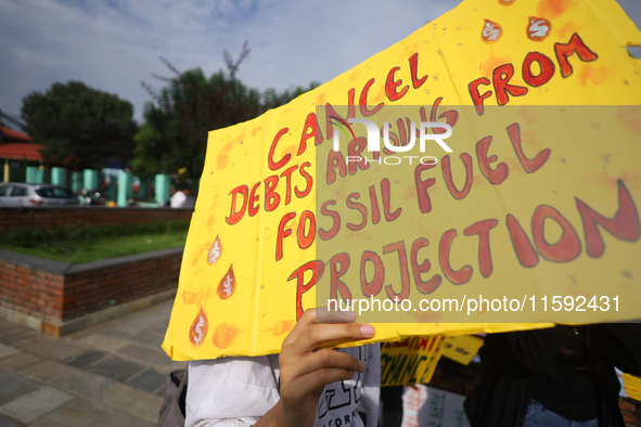 A Nepali activist displays a slogan calling for climate justice during a march to mark the Global Week of Action for Peace and Climate Justi...