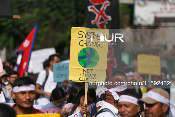 A Nepali activist displays a slogan calling for climate justice during a march to mark the Global Week of Action for Peace and Climate Justi...