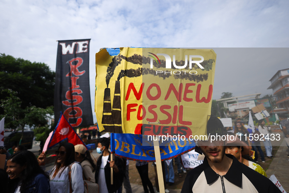 A Nepali activist displays a slogan calling for climate justice during a march to mark the Global Week of Action for Peace and Climate Justi...