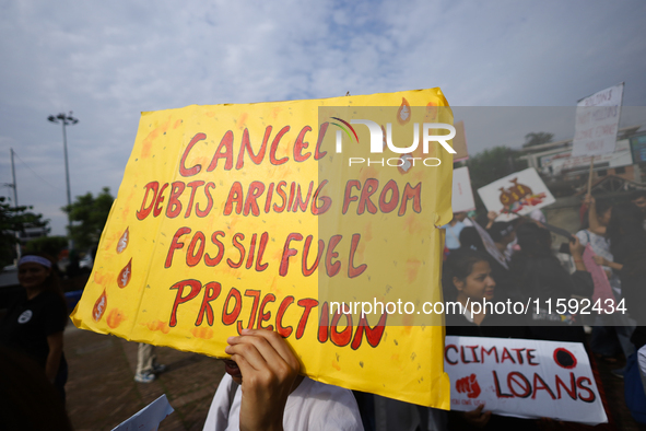 A Nepali activist displays a slogan calling for climate justice during a march to mark the Global Week of Action for Peace and Climate Justi...