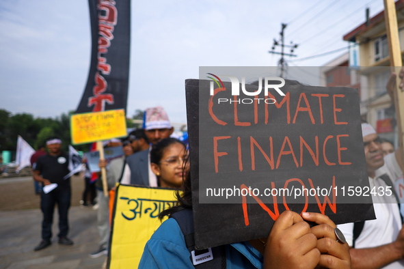 A Nepali activist displays a slogan calling for climate justice during a march to mark the Global Week of Action for Peace and Climate Justi...