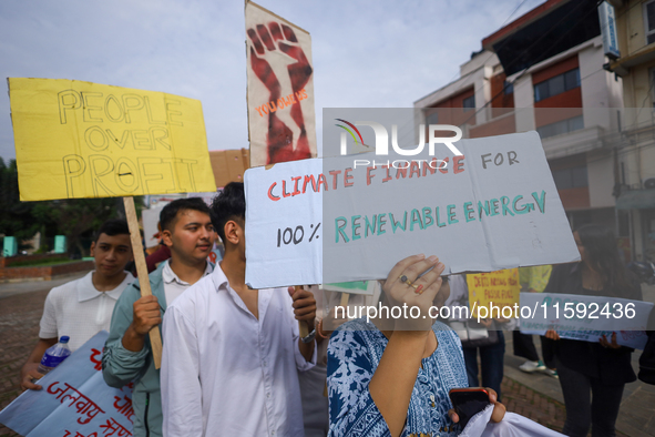 Nepali activists display a slogan calling for climate justice during a march to mark the Global Week of Action for Peace and Climate Justice...