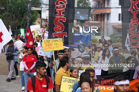 Nepali activists display a slogan calling for climate justice during a march to mark the Global Week of Action for Peace and Climate Justice...