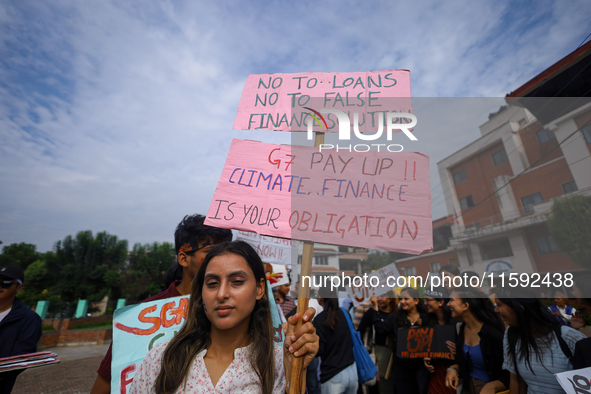 A Nepali activist displays a slogan calling for climate justice during a march to mark the Global Week of Action for Peace and Climate Justi...