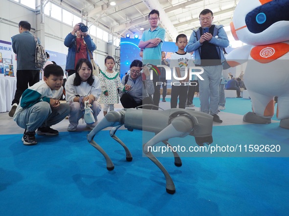 Visitors watch a performance of a four-legged robot during the 2024 National Science Popularization Day in Beijing, China, on September 21,...