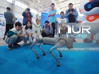 Visitors watch a performance of a four-legged robot during the 2024 National Science Popularization Day in Beijing, China, on September 21,...