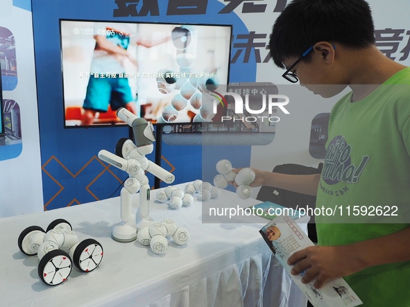 A child interacts with a robot during the 2024 National Science Popularization Day in Beijing, China, on September 21, 2024. 