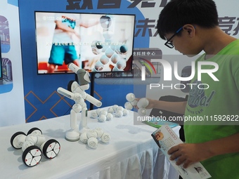 A child interacts with a robot during the 2024 National Science Popularization Day in Beijing, China, on September 21, 2024. (