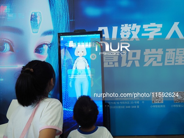 A child talks with an AI digital human at the 2024 National Science Popularization Day in Beijing, China, on September 21, 2024. 